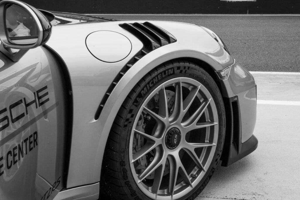 Une voiture gris avec des pneus Michelin montés. On ne peut voir que la roue avant. Elle accompagne le post " Différence entre le pneu Michelin et Goodyear "