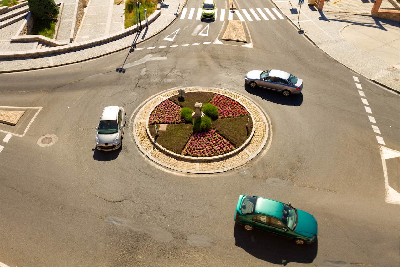 Des voitures circulent autour d'un rond-point.