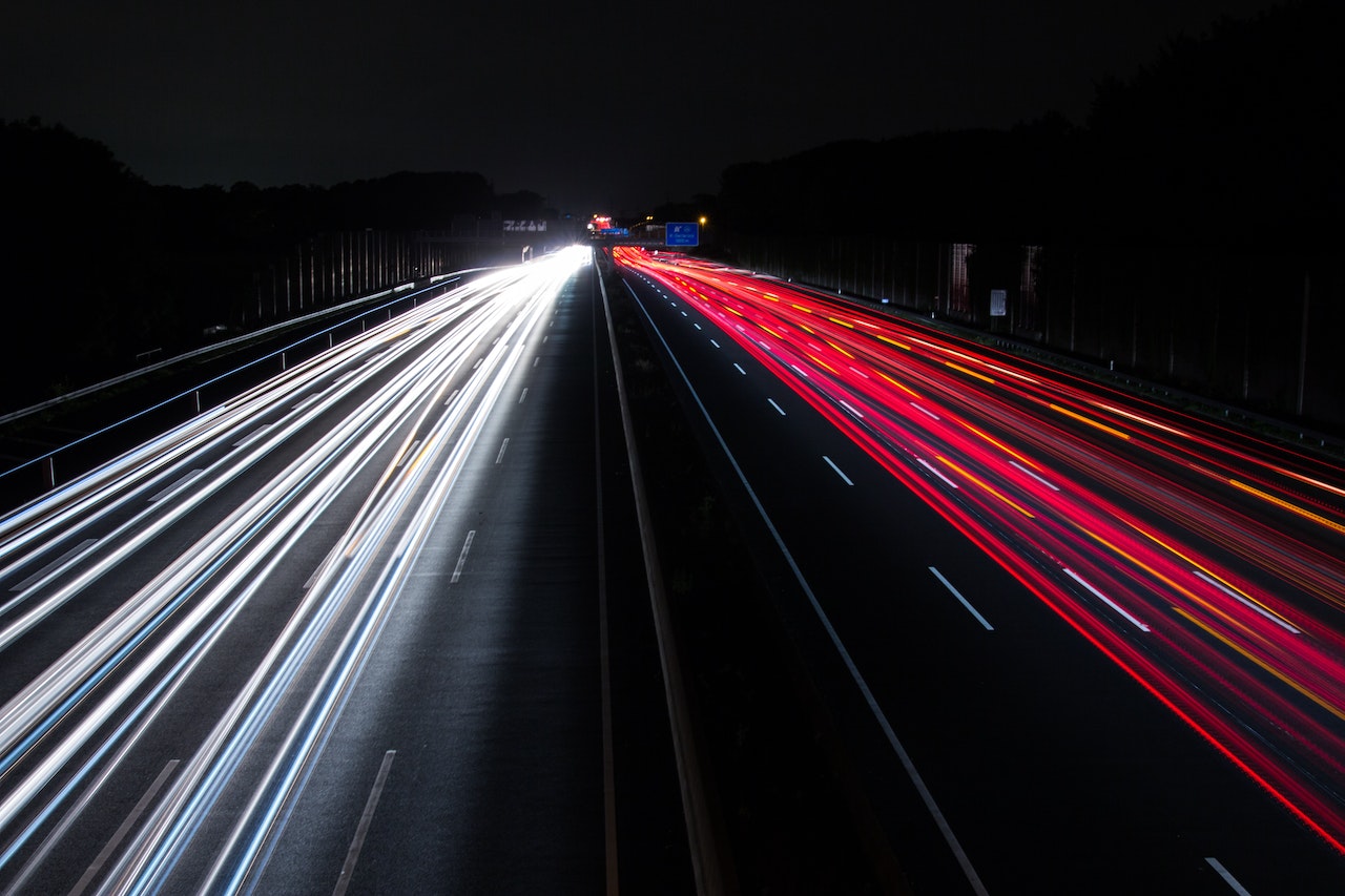 Feux rouges et blancs de voitures sur une route.